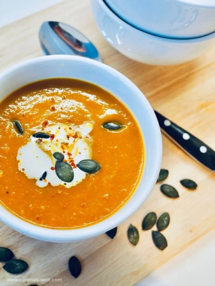 Weltbeste Kürbissuppe in einer Schüssel, serviert mit frischen Kräutern.